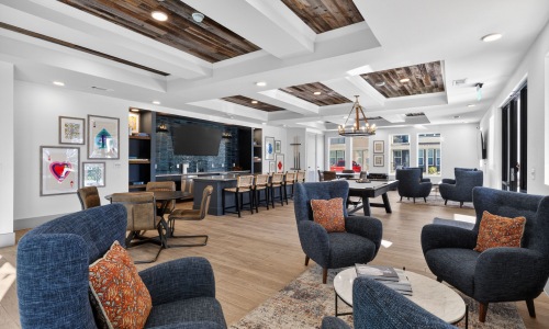 Resident clubhouse at Aspire at Sherman featuring lounge seating, entertainment space, and modern community amenities.